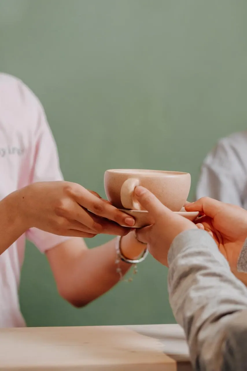 Dos manos compartiendo una taza de café en Mayirevo