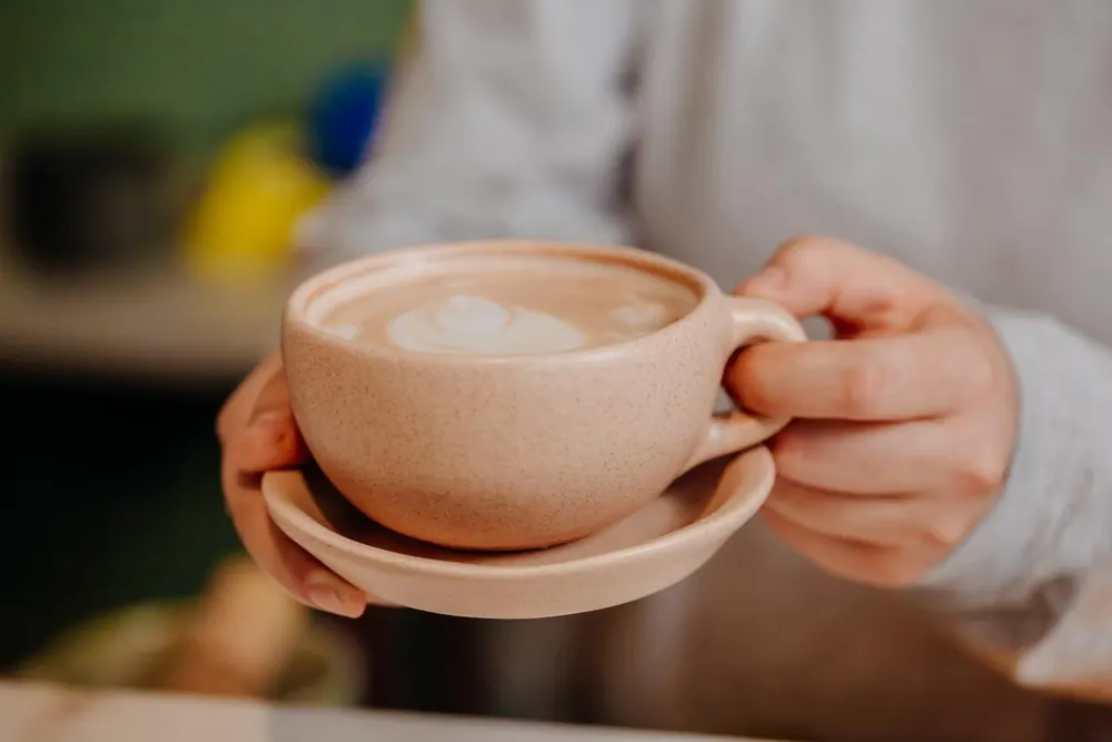 Manos sosteniendo una taza de café recién preparado